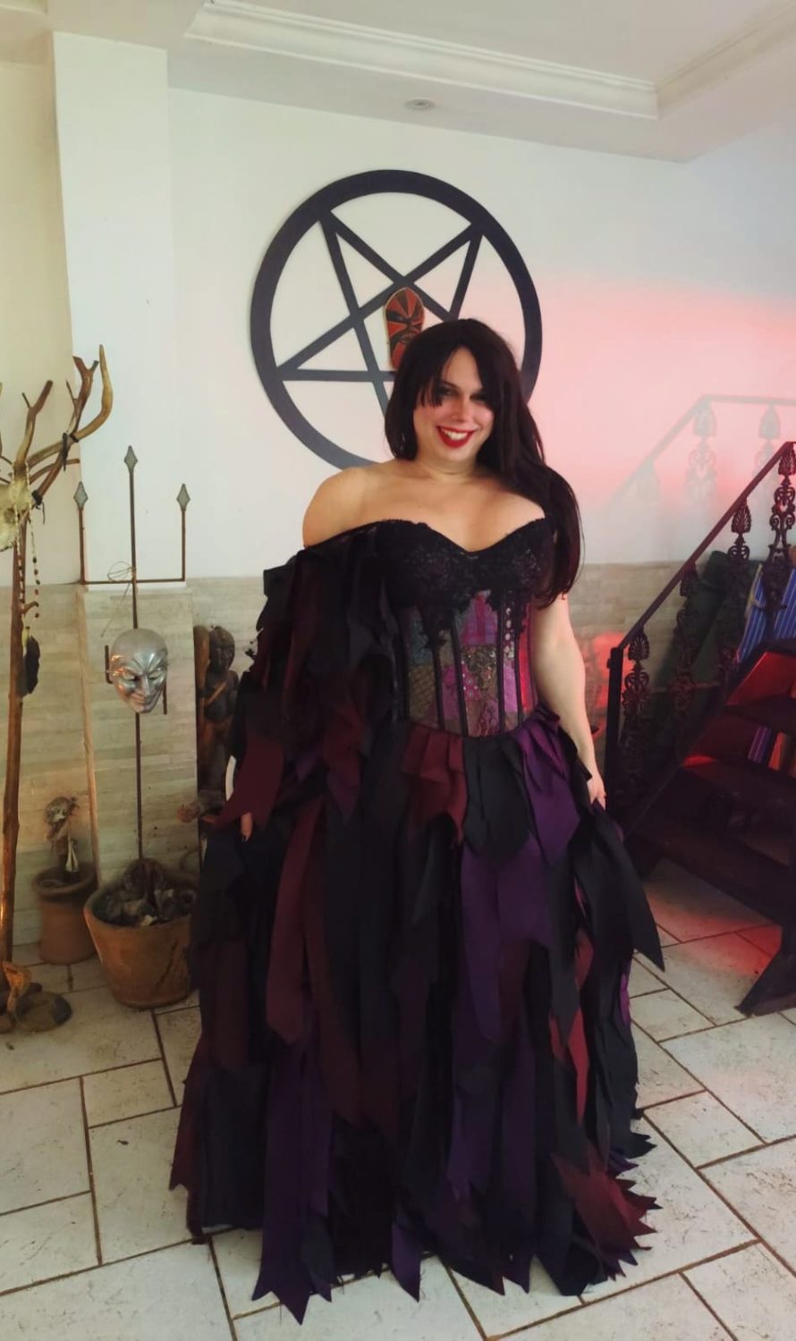 Dirigente do Templo da Serpente Negra em vestido ritual escuro com pentagrama e santuário ao fundo